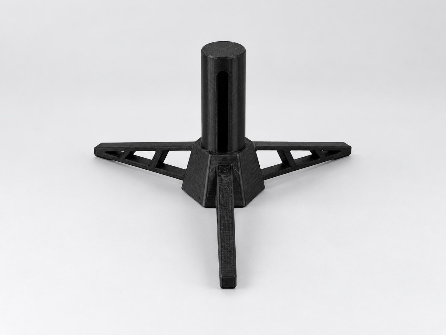 Black tripod desktop stand with open truss legs and a slotted peg