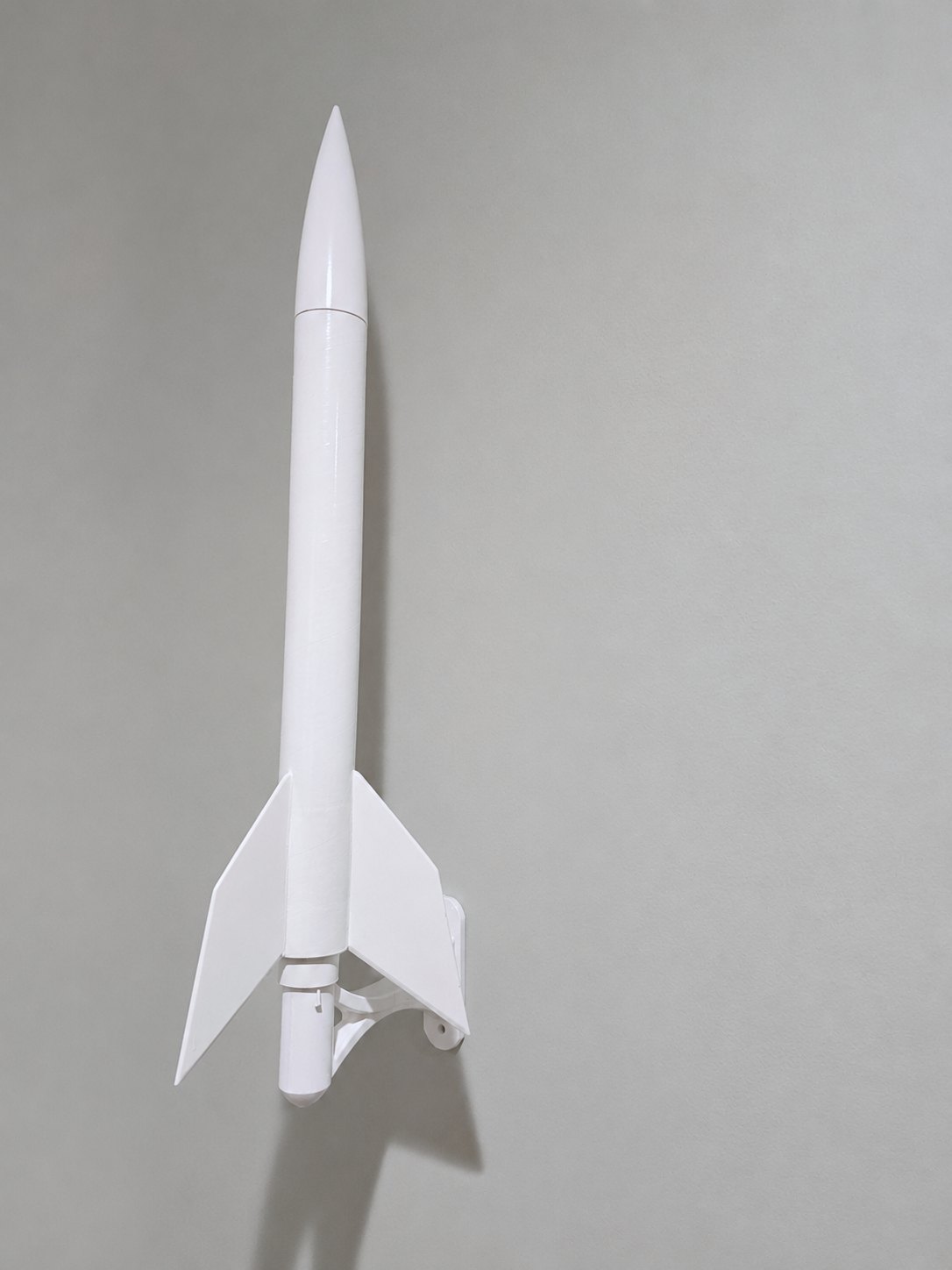 Model rocket displayed vertically on the ITERA curved-arm bracket